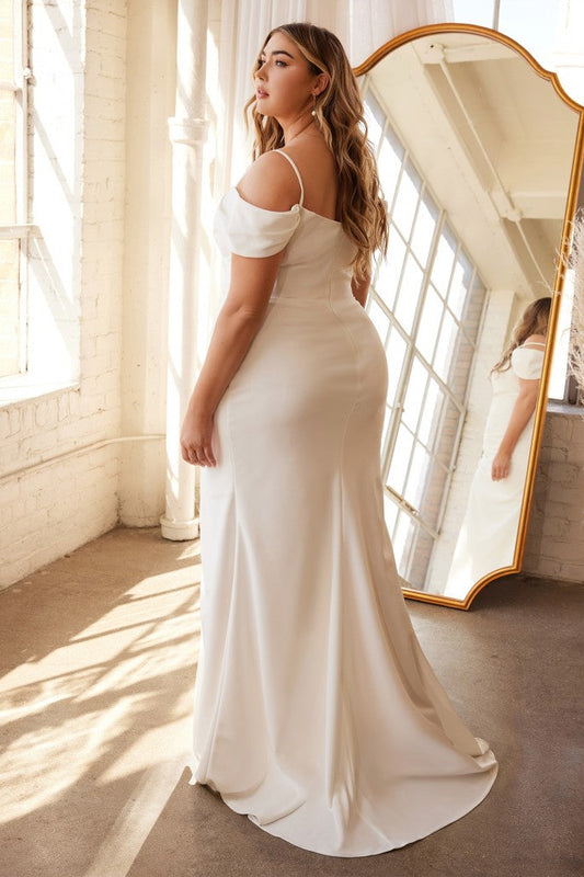 Designed for a more modern bride or small intimate wedding this sophisticated gown is perfection. The off the shoulder pleated sleeve drapes around the shoulders while a thin strap holds the gown. A sweetheart neckline pleats into the side seam for a flattering fit opening up to a subtle leg slit