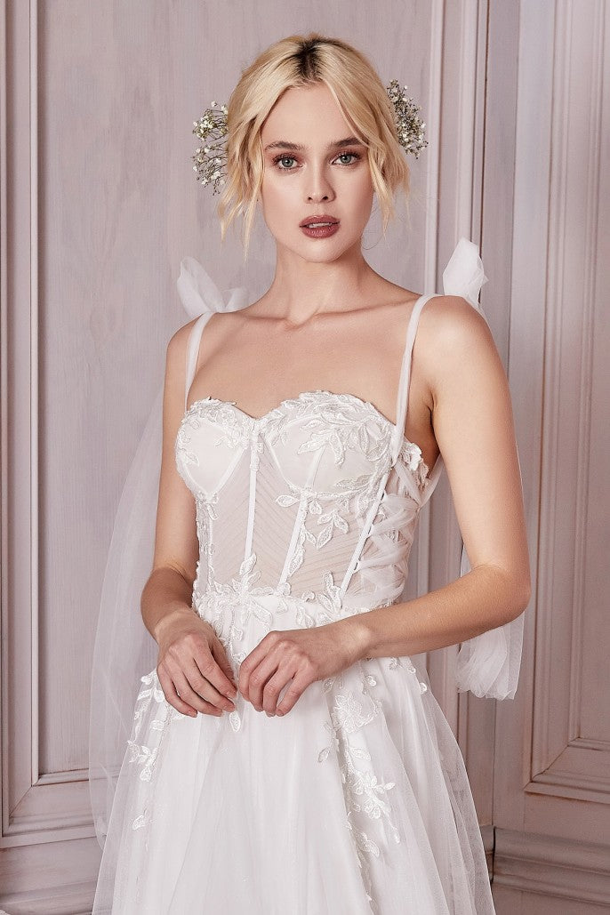 Walk down the aisle in this truly breathtaking bridal gown. Fitted in the bodice a structured corset accentuates modern bust lines. Lace appliques detail the neckline and trickle down the waist. The side seam details a sheer lace with a tulle criss cross strap shaping out to a lace up open back. An A-line silhouette flows out from the waist in layers of luxe tulle and horsehair braid hem.