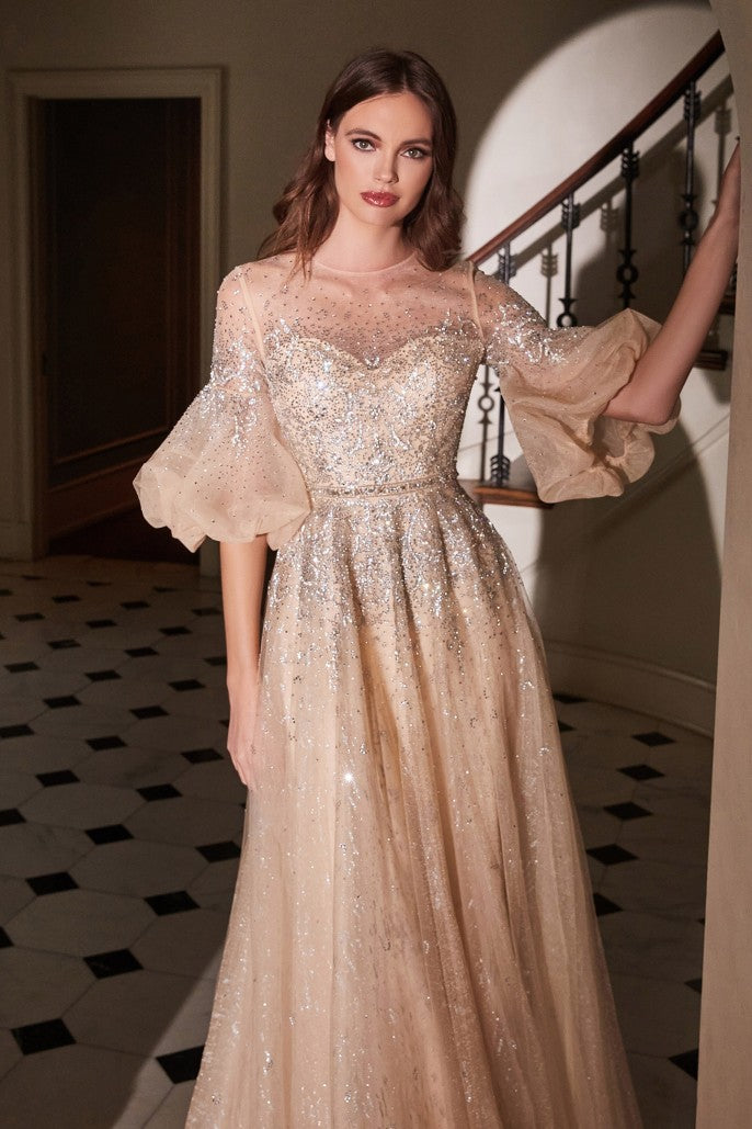Dazzle the room in this beaded puff mid-sleeve tulle dress with A-line skirt. This beautiful gown features a sheer sweetheart bodice, couture puff sleeves, enclosed illusion back, and a full length A-line skirt that ends in a sweep train. Embellished Puff Sleeve Tulle Gown Illusion sweetheart bodice with couture puff sleeves Sheer enclosed back Floor length A-line skirt with sweep train Details: Bra Cup, Fully Lined Fit: The model is 5'8" and is wearing 4" heels