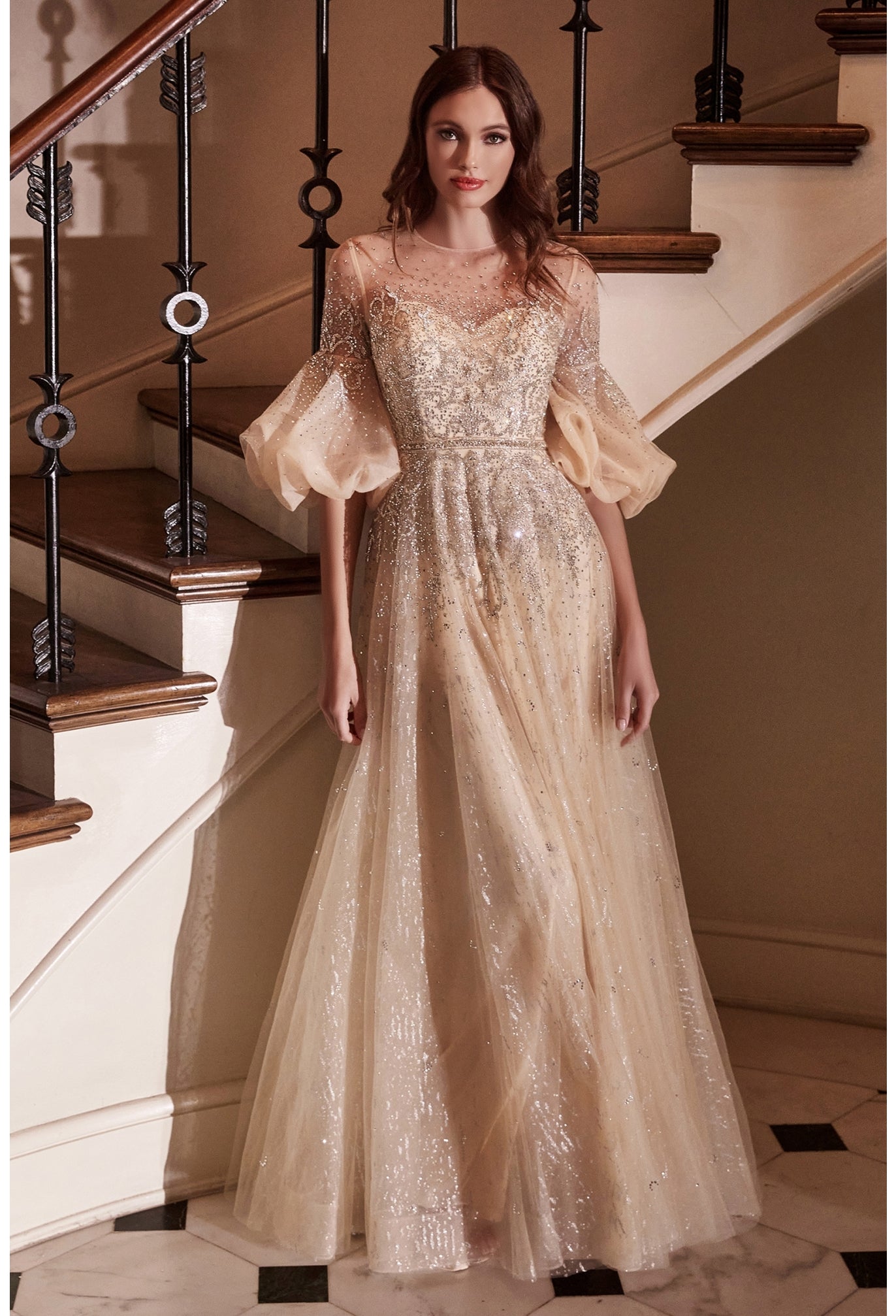 Dazzle the room in this beaded puff mid-sleeve tulle dress with A-line skirt. This beautiful gown features a sheer sweetheart bodice, couture puff sleeves, enclosed illusion back, and a full length A-line skirt that ends in a sweep train. Embellished Puff Sleeve Tulle Gown Illusion sweetheart bodice with couture puff sleeves Sheer enclosed back Floor length A-line skirt with sweep train Details: Bra Cup, Fully Lined Fit: The model is 5'8" and is wearing 4" heels