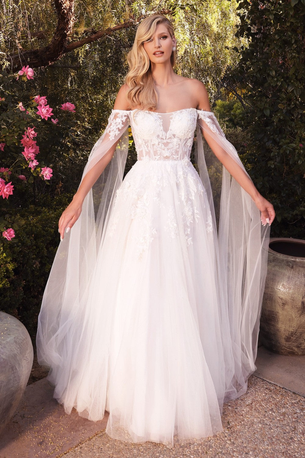 This diaphanous gown features a sheer strapless bodice and frothy A-line skirt cut from layers of soft tulle to a floor-sweeping hem. The bodice has supportive internal boning to ensure it stays in place and is framed by elongated tulle sleeves split along the inseam, falling to meet the hem of the skirt and conjuring up an ethereal mood. Hand cut degrade lace placements flower about with pearlescent beaded accents.