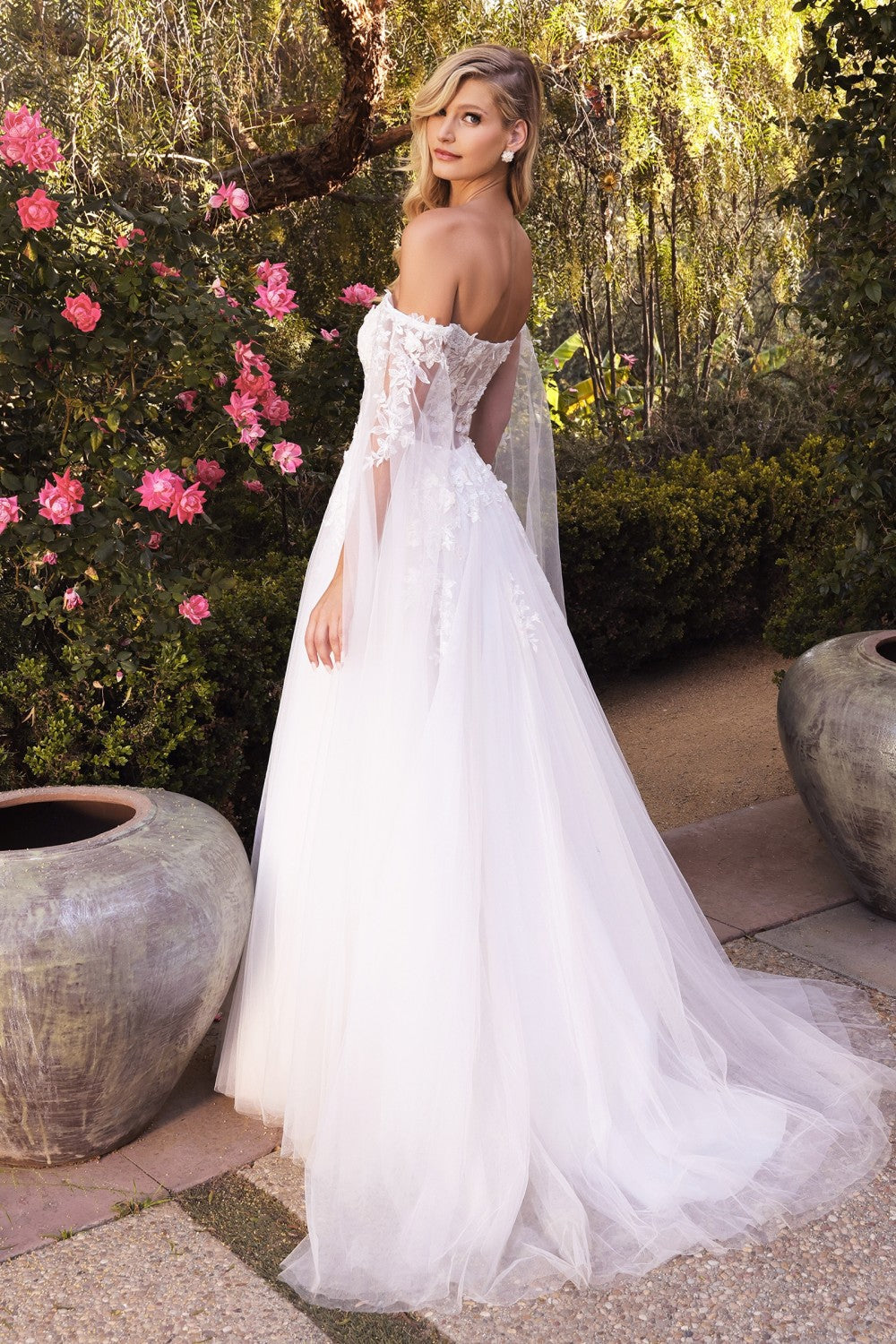 This diaphanous gown features a sheer strapless bodice and frothy A-line skirt cut from layers of soft tulle to a floor-sweeping hem. The bodice has supportive internal boning to ensure it stays in place and is framed by elongated tulle sleeves split along the inseam, falling to meet the hem of the skirt and conjuring up an ethereal mood. Hand cut degrade lace placements flower about with pearlescent beaded accents.