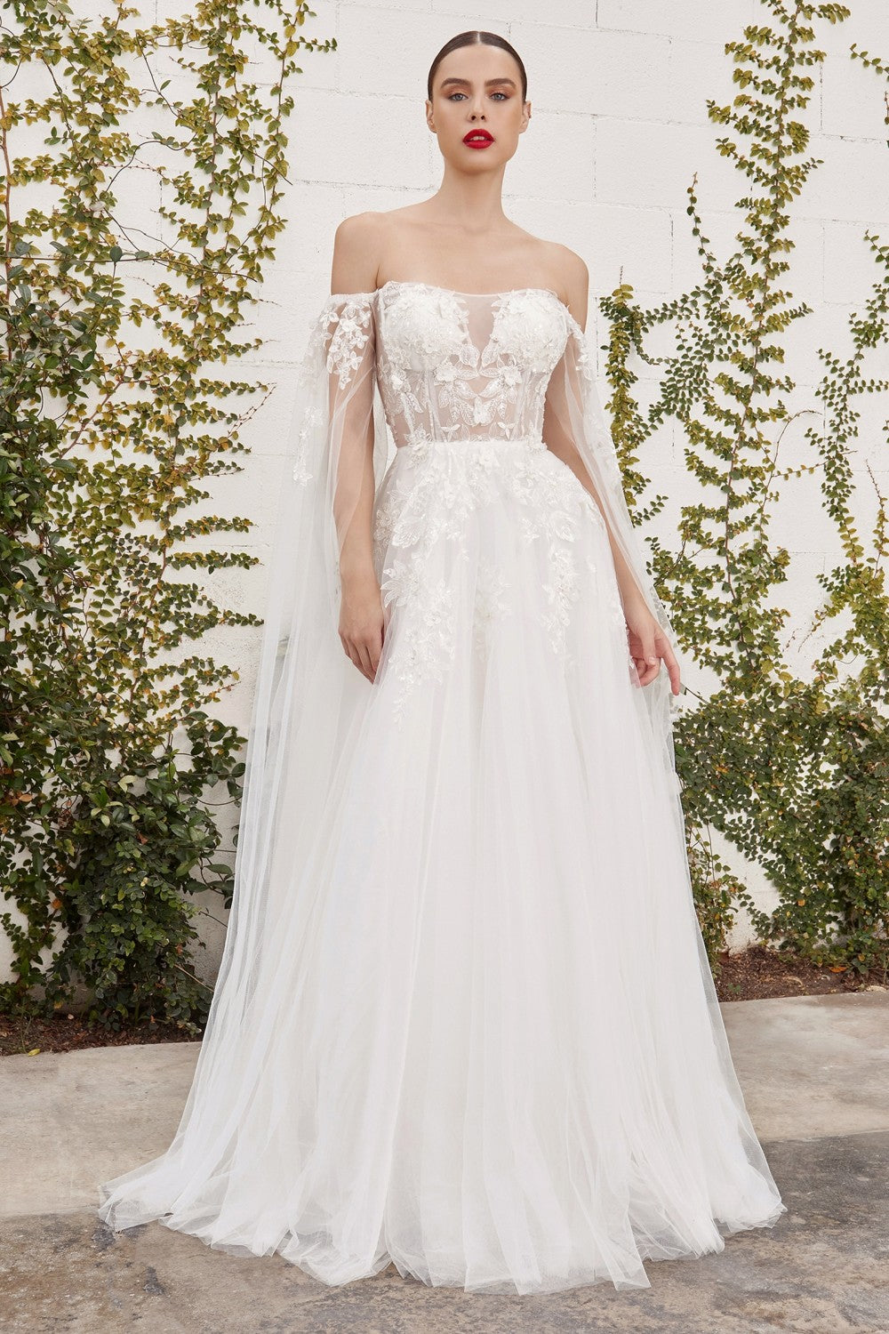 This diaphanous gown features a sheer strapless bodice and frothy A-line skirt cut from layers of soft tulle to a floor-sweeping hem. The bodice has supportive internal boning to ensure it stays in place and is framed by elongated tulle sleeves split along the inseam, falling to meet the hem of the skirt and conjuring up an ethereal mood. Hand cut degrade lace placements flower about with pearlescent beaded accents.
