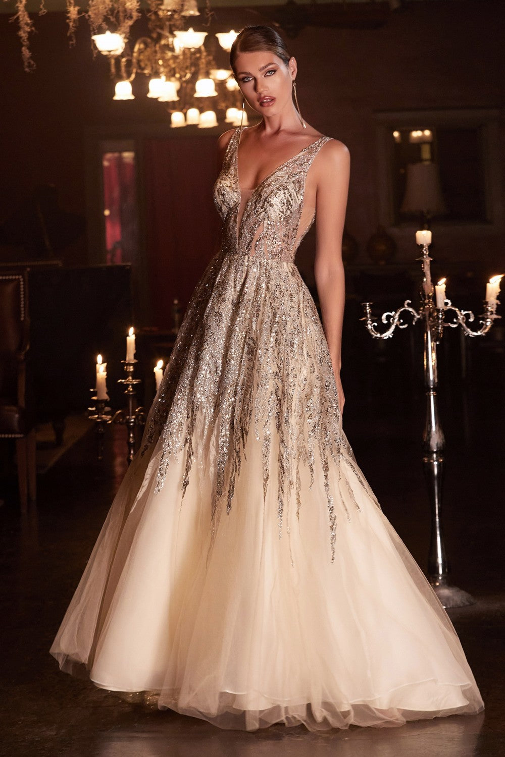 Dance the night away in this layered tulle ball gown. Shimmering glitter and bead embellishment adorn this gown from bodice to skirt. Styled with a deep plunging neckline, open back and illusion cut out sides.
