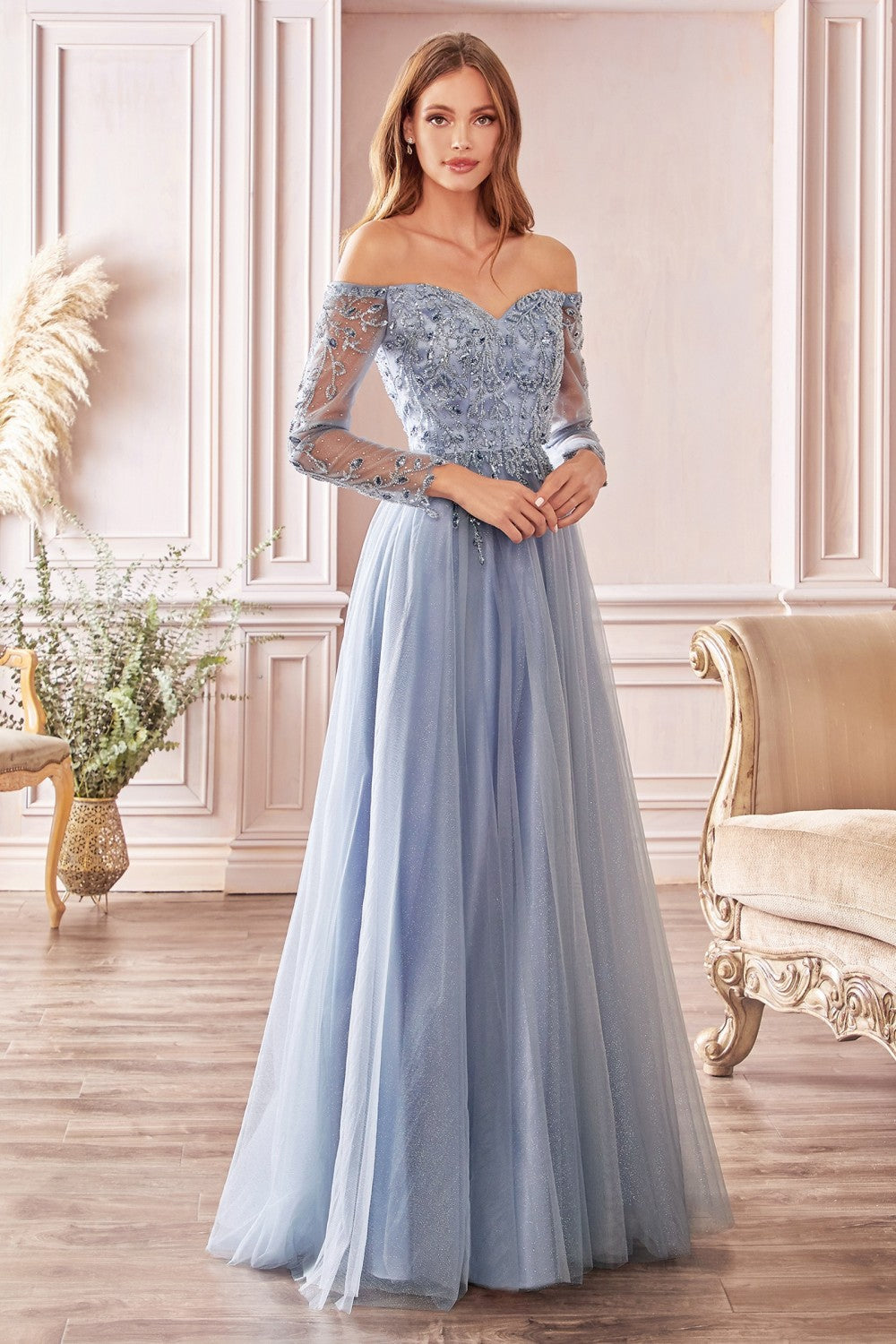 Captivate the room in this beaded long off the shoulder A-line glitter tulle dress with sheer 3/4 sleeves and A-line skirt. A-line off the shoulder layered glitter tulle gown with floral beaded bodice Off the shoulder sweetheart bodice with illusion 3/4 sleeves Open back Floor length A-line skirt Details: Bra