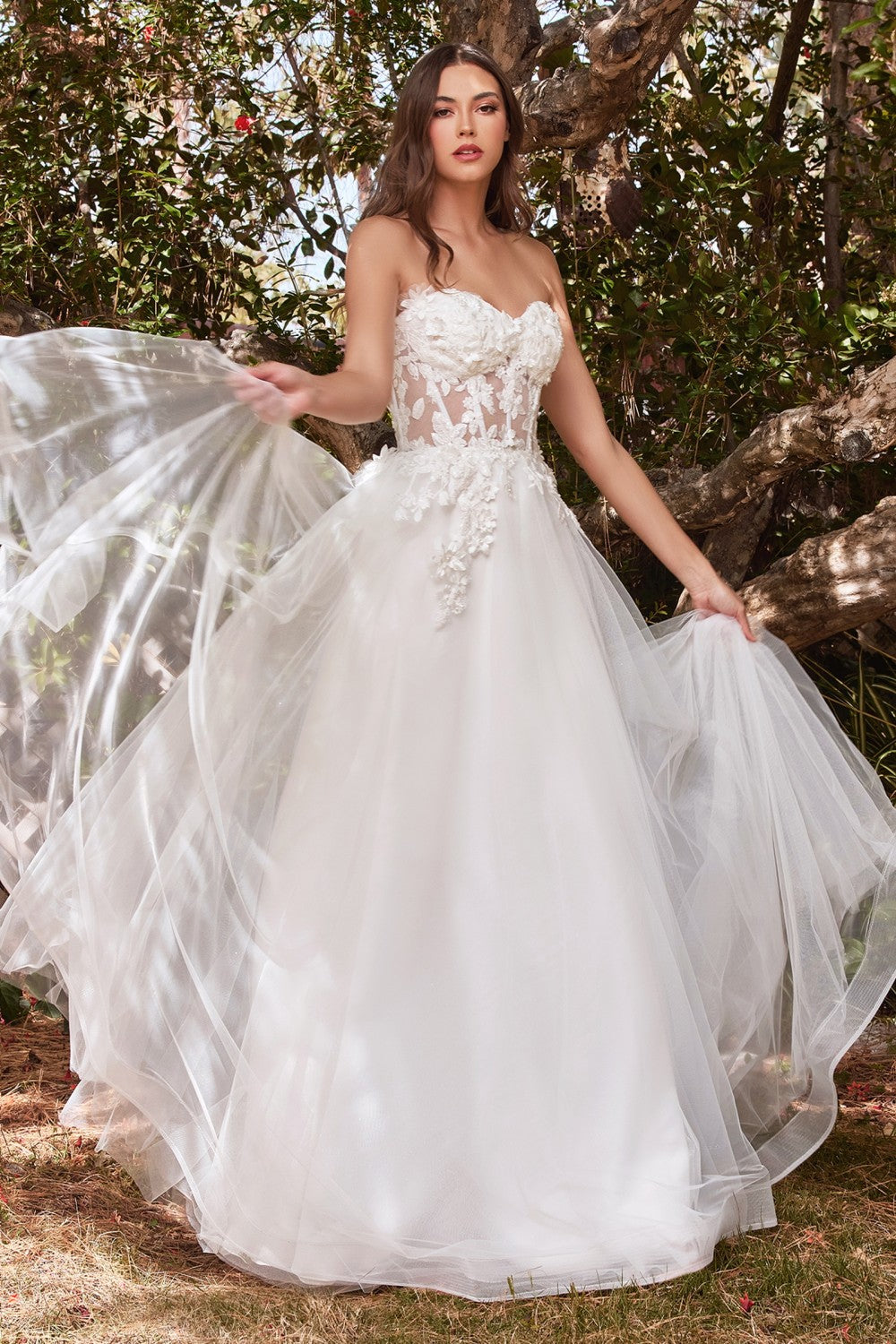 Cut from layers of tulle, this princess gown features a sheer tulle corseted bodice, detachable off-the-shoulder blouson sleeves, and a lightly gathered skirt with flowing proportions. The bodice is strategically embellished at the bust, waist and sleeves blooming with floral appliques. Its strapless sweetheart neckline is softened with a lace applique edge.