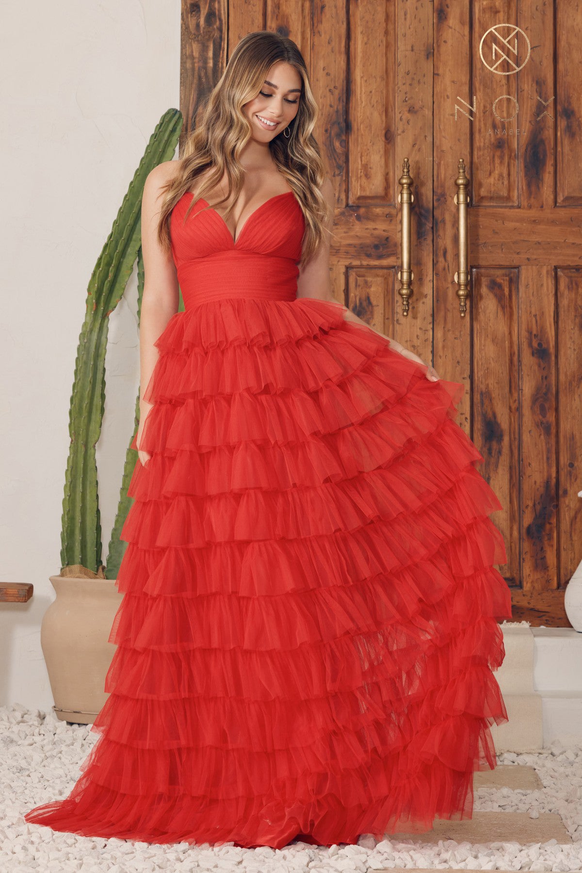 Available in red or black. Exquisite tulle gown that exudes elegance and charm. This stunning piece features beautifully ruffled layers that add depth and dimension to the overall design. A flattering V-neckline, coupled with delicate spaghetti straps, completes the look and creates a cohesive and sophisticated effect. Fabric: 100% Satin.