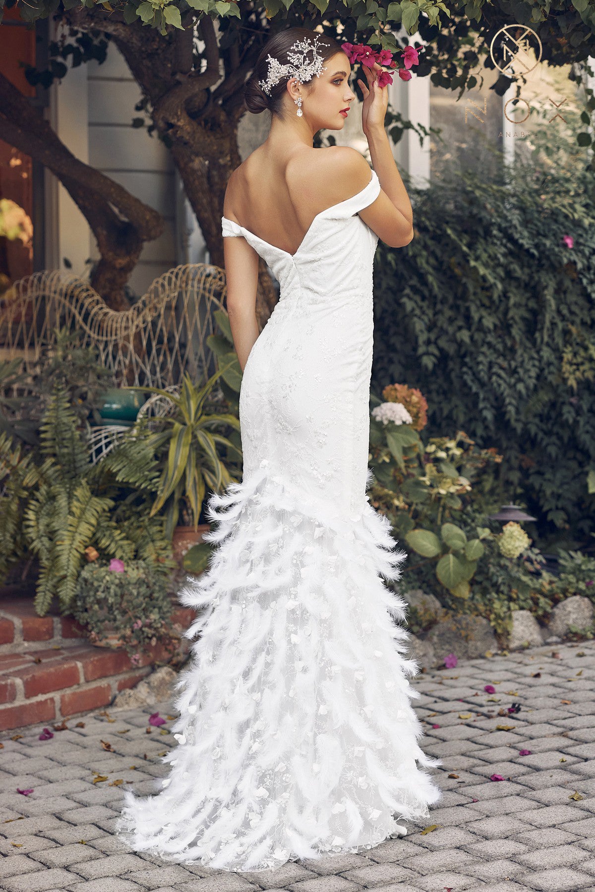 Off-shoulder gown with a fitted silhouette, featuring a stunning beadwork design and feathered accents. The skirt creates a sheath silhouette that flows to the full-length hem.