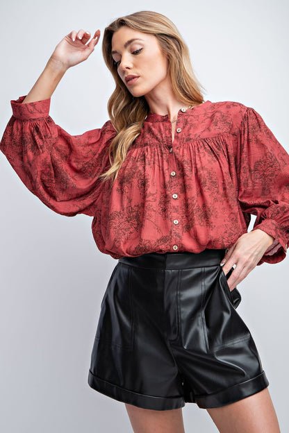 Relaxed fit smock style top with 3/4 sleeves and rounded hem. Featured with floral print, bishop sleeves, crepe button down front and cliffs. Material: 65% Rayon 35% Polyester.