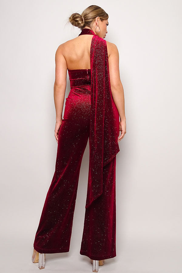 Burgundy color. Scarf top glitter velvet jumpsuit. Sleeveless one shoulder, diagonal neckline with a wraparound detailed scarf. Front side pockets and open back detail. Long pants that elongate the legs. Looser fit toward the bottom to keep you comfortable. Invisible back zip closure. 95% Polyester 5% Spandex