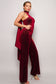 Burgundy color. Scarf top glitter velvet jumpsuit. Sleeveless one shoulder, diagonal neckline with a wraparound detailed scarf. Front side pockets and open back detail. Long pants that elongate the legs. Looser fit toward the bottom to keep you comfortable. Invisible back zip closure. 95% Polyester 5% Spandex