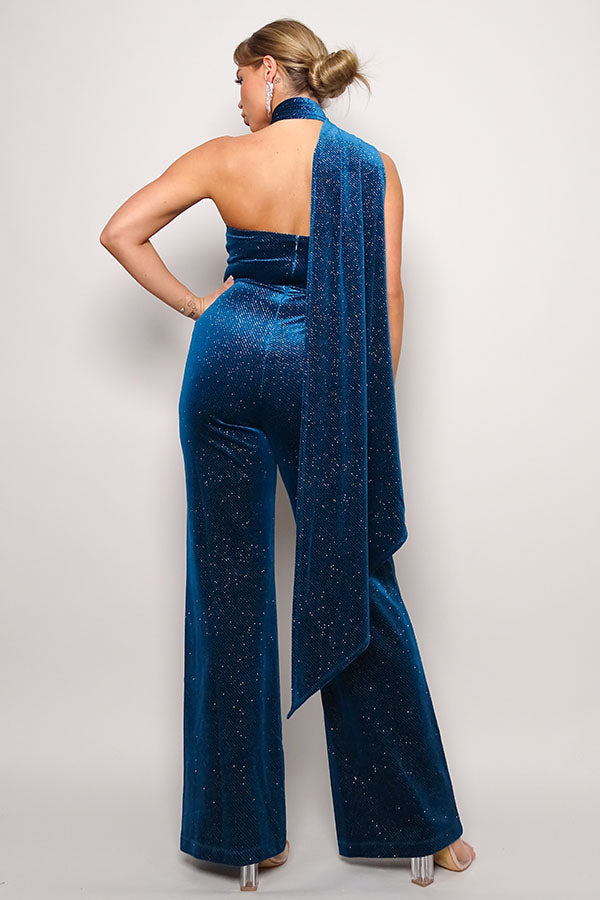 Teal color. Scarf top glitter velvet jumpsuit. Sleeveless one shoulder, diagonal neckline with a wraparound detailed scarf. Front side pockets and open back detail. Long pants that elongate the legs. Looser fit toward the bottom to keep you comfortable. Invisible back zip closure. 95% Polyester 5% Spandex