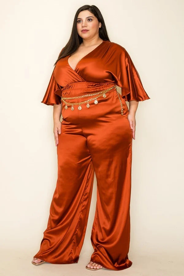 Cognac color. Satin wrap front short sleeve smocked waist jumpsuit with chain belt.                              97% Polyester 3 % Spandex 