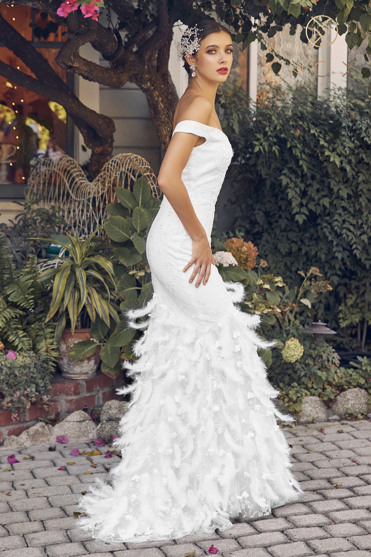 Off-shoulder gown with a fitted silhouette, featuring a stunning beadwork design and feathered accents. The skirt creates a sheath silhouette that flows to the full-length hem.